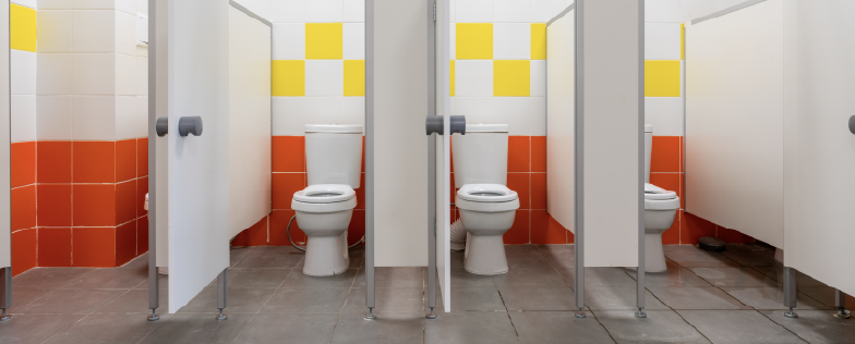 Row of toilet stalls with bright tiles 
