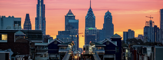 Aerial view of Benjamin Franklin Bridge and Philadelphia skyline on a colorful sunset sky background
