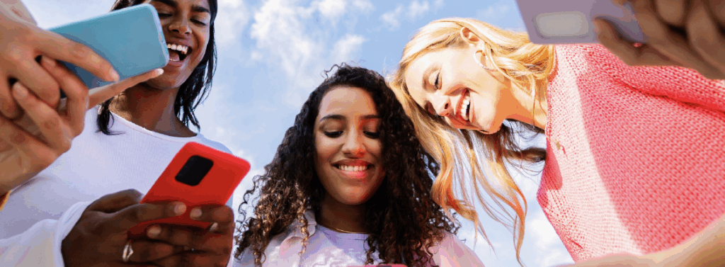 Low angle view of young group of multicultural women using mobile phones