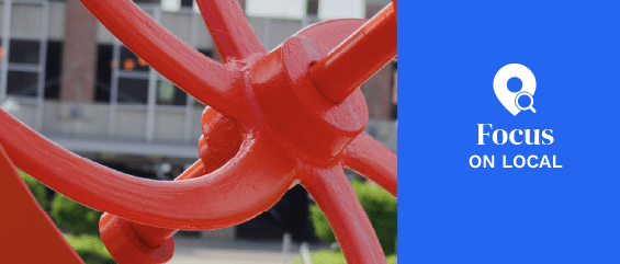 a large red sculpture sitting on top of a sidewalk