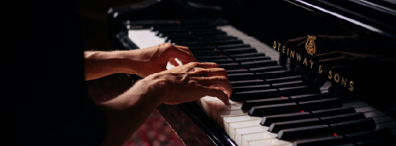 person playing black upright piano