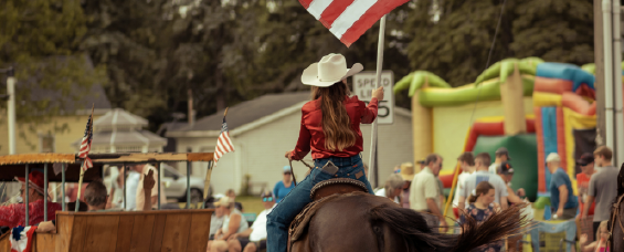 a person riding a horse while carrying a flag a person riding a horse while carrying a flag